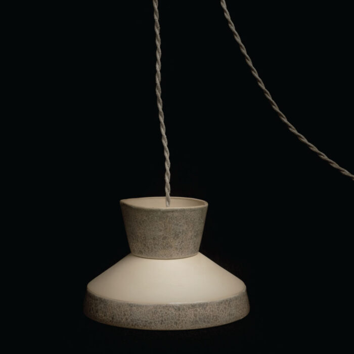 Een rauwe, handgemaakte lamp van AtelierNVMBR. Gemaakt van keramiek, ontworpen als functioneel kunstwerk. Elk exemplaar is uniek en brengt karakter, sfeer en stilte in elke ruimte.